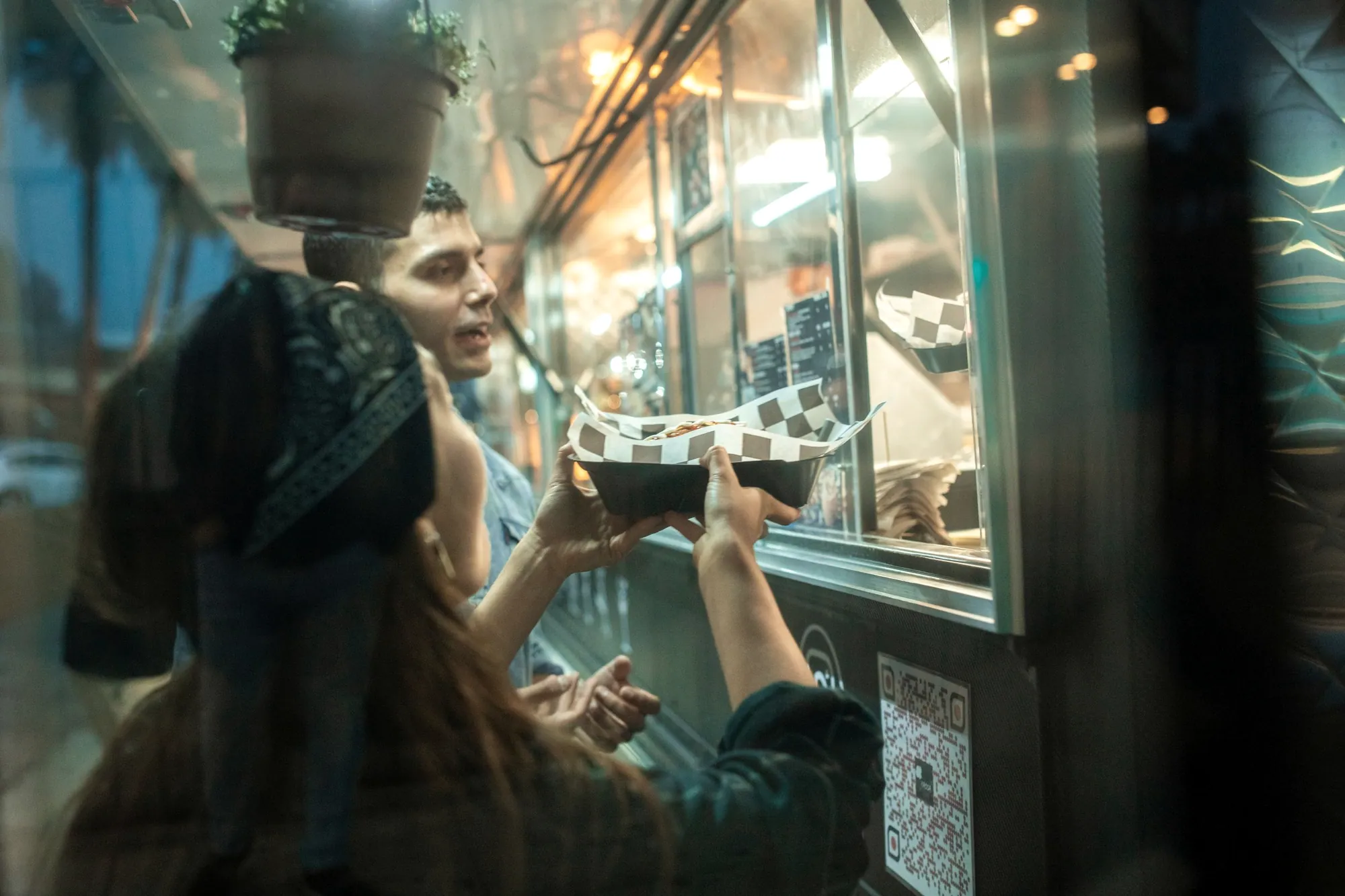 Guests ordering from a street food truck at night