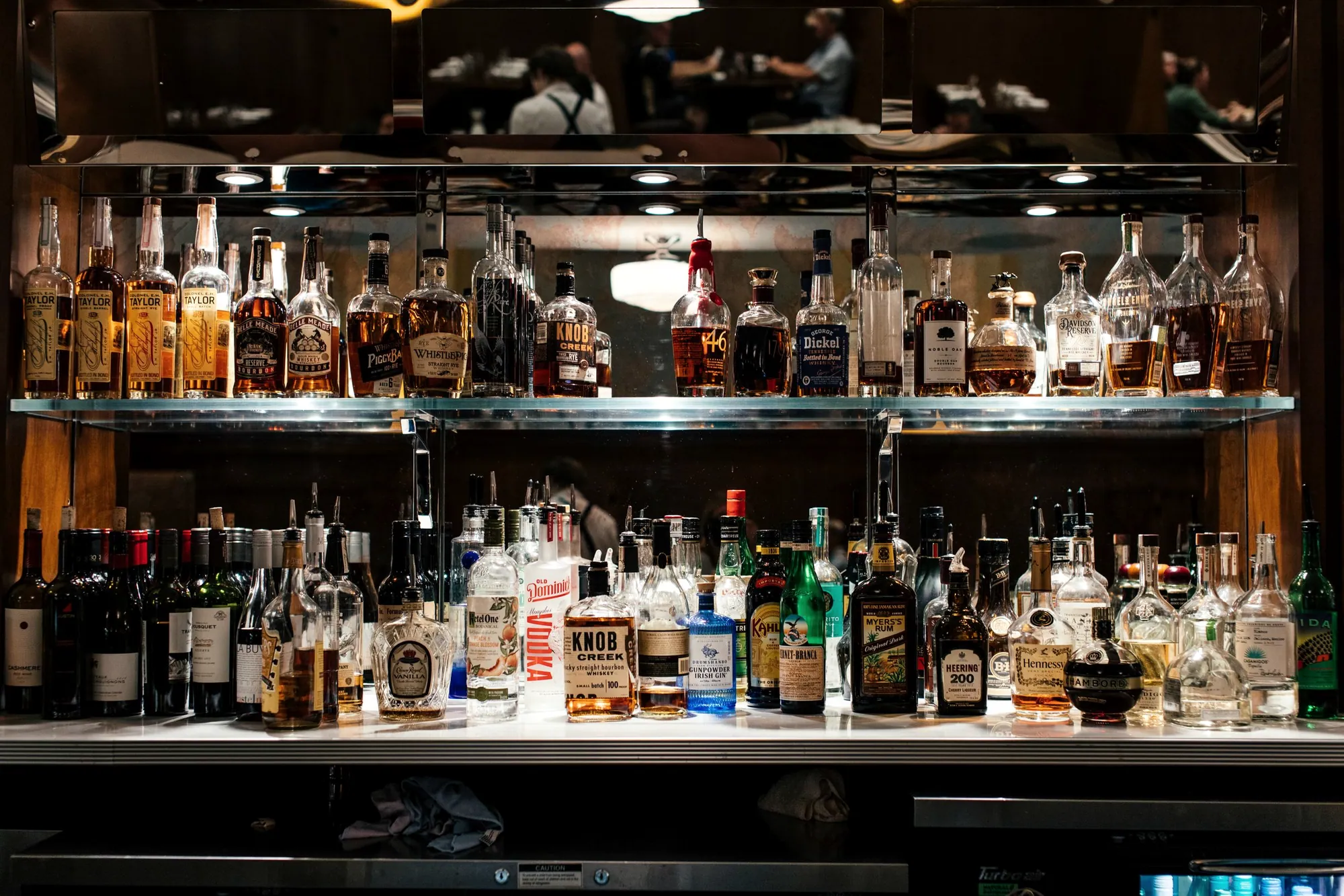 Liquor bottles on a lit bar shelf