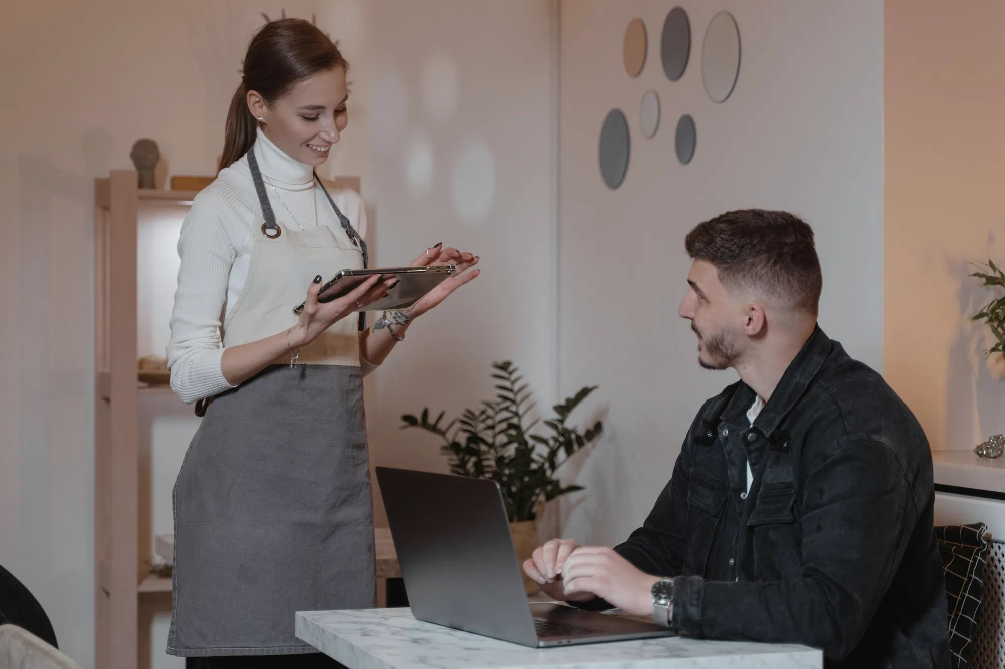 Server taking an order on a handheld tablet at a table